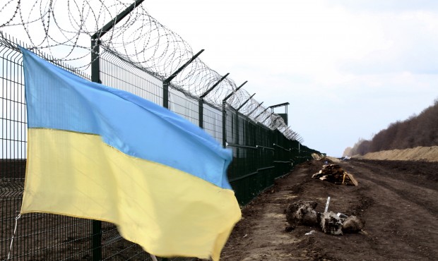 In this photo taken on Saturday, April 18, 2015, a Ukrainian national flag is attached to the fence...