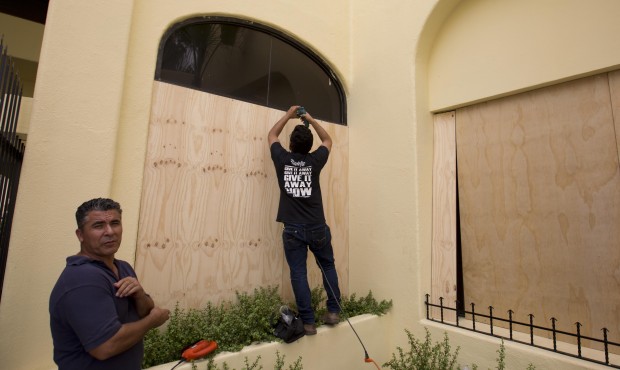 n Workers board over store front windows in preparation for Hurricane Blanca, in Cabo San Lucas, Me...