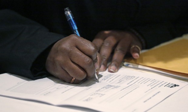 FILE – In this April 22, 2015 file photo, a job seeker fills out an application during a Nati...
