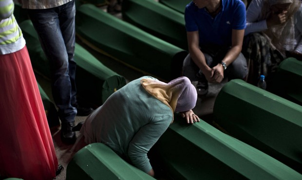 A woman mourns next to a coffin containing the remains of her relative at the Potocari memorial com...