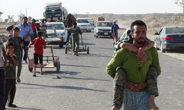Iraqi family members who left their hometown of Ramadi walk towards Baghdad, outside Ramadi, the ca...