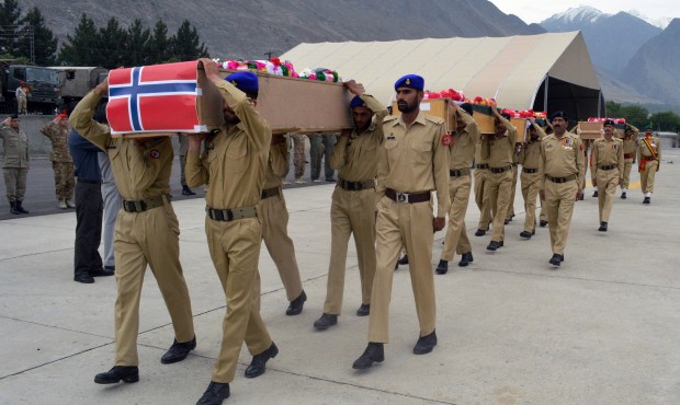 Pakistani soldiers carry the caskets of victims of a helicopter crash to a military plane prior to ...