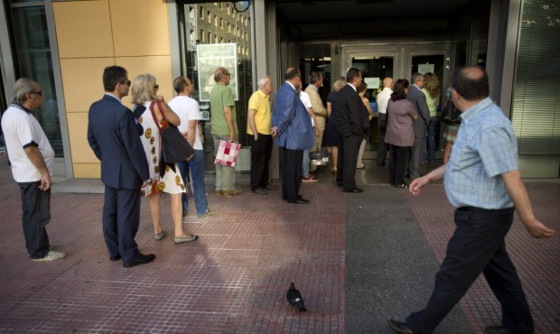 People line up to withdraw cash from a bank machine in central Athens, Wednesday, July 8, 2015. Fru...