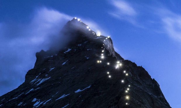 Lamps illuminate the path of the first ascent on the Matterhorn mountain, seen from the Hoernli mou...