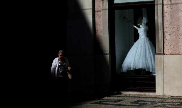 A woman walks past a shop displaying a bridal dress in the Baixa neighbourhood in downtown Lisbon, ...