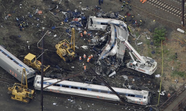 n In this aerial photo, emergency personnel work at the scene of a deadly train wreck, Wednesday, M...