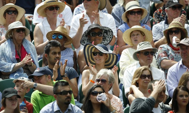 Spectators sit on Centre Court as they watch the singles match between Novak Djokovic of Serbia and...