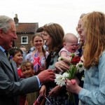 Britain's Prince Charles, the Prince of Wales, with 6 month old Emily Scott, as he meets crowds of well wishers on a visit to Bugthorpe, England, Tuesday July 23, 2013. It's Day One of parenting for Prince William and Kate. After the excitement and fatigue and joy of childbirth _ emotions shared with a nation _ the young couple is expected Tuesday to bring the prince home from St. Mary's Hospital in London. Prince Charles is a grandfather for the first time. (AP Photo /Anna Gowthorpe/PA) 