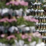 A South Korean woman stands near a tree of flowerpots during an environmental campaign as part of Earth Day celebrations in front of Seoul City Hall in Seoul, South Korea, Monday, April 22, 2013. (AP Photo/Lee Jin-man)