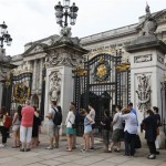 People queue to look at a notice proclaiming the birth of a baby boy of Prince William and Kate, Duchess of Cambridge on display for the public view at Buckingham Palace in London, Tuesday, July 23, 2013. (AP Photo/Sang Tan)