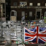 A Union Flag hangs on a barrier in front of media ladders outside the Lindo Wing at St Mary's Hospital in London, Monday, July 15, 2013. Britain's Kate, the Duchess of Cambridge plans to give birth to her first child who will be third-in-line to the throne at the hospital in mid-July. (AP Photo/Kirsty Wigglesworth)