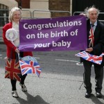 Royal enthusiasts unveil a banner congratulating Britain's Prince William and Kate, Duchess of Cambridge on the birth of the Prince of Cambridge, outside the entrance of the private Lindo Wing at St. Mary's Hospital in London, Tuesday, July 23, 2013. It's Day One of parenting for Prince William and Kate. After the excitement and fatigue and joy of childbirth, emotions shared with a nation, the young couple is expected to bring the prince home Tuesday. (AP Photo/Alastair Grant)