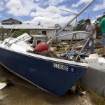 James Creamer, left, looks at the remains of his sailboat with friend Jamie Guthrie in Eastpoint, Fla., Tuesday, June 26, 2012. Tropical Storm Debby continues to pound the Florida gulf coast as it slowly meanders north. (AP Photo/Dave Martin)