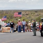 Protesters gather near the entrance to juvenile facility in an effort to stop a bus load of Central American immigrant children from being delivered to the facility, Tuesday, July 15, 2014, in Oracle, Ariz. Federal officials delayed the bus with no details on whether the children will arrive or not. (AP Photo/Matt York)