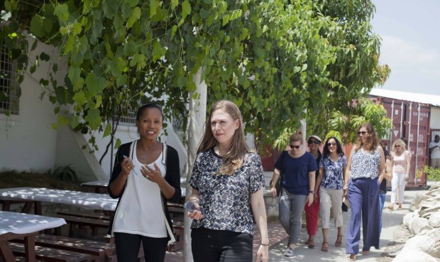 Chelsea Clinton, right, walks with Magalie Dresse, owner of Caribbean Craft, during a visit to the ...